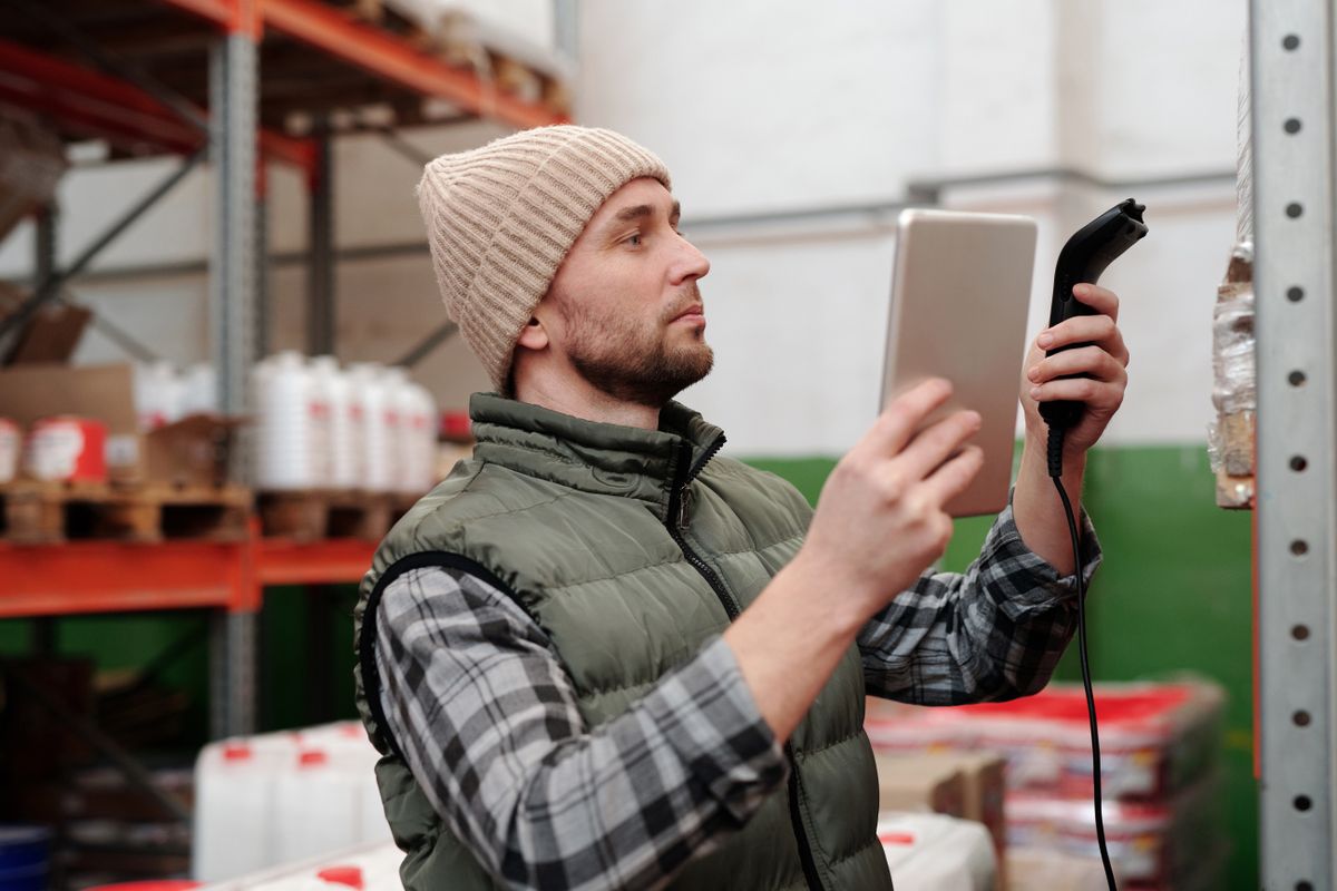 Operario relevando stock con tablet y escáner en el depósito